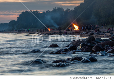 Unrecognisable people celebrating summer solstice with bonfires on beach Unrecognisable people celebrating summer solstice with bonfires on beach 66551783