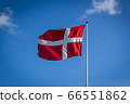 Danish flag in sunshine against blue sky with clouds, horizontal 66551862