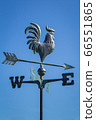 Weather vane showing direction of wind against clear blue sky, vertical 66551865