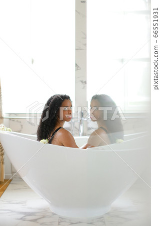 Black young girl taking bath and relaxing, reflection in glass. 66551931