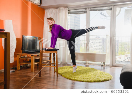 Positive aged woman training at living room 66553301