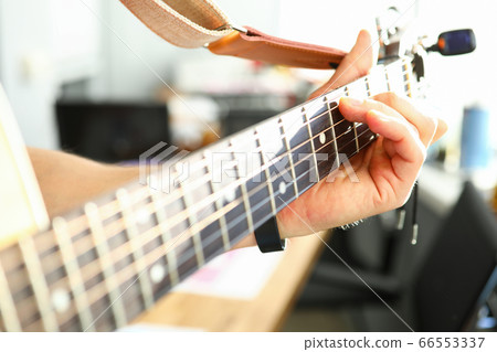 Man plays guitar, male hand holds neck guitar 66553337