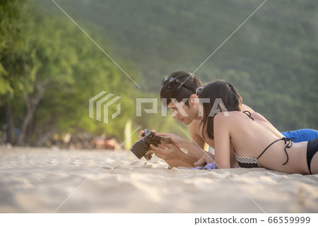 Happy young honeymoon couple on beach having Happy young honeymoon couple on beach having 66559999