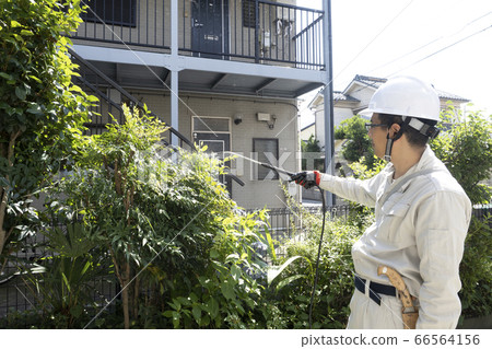 Worker watering plants 66564156