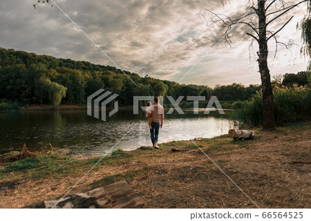 Mother and baby girl sitting near lake. Local travel. New normal vacation. Mother's day Mother and baby girl sitting near lake. Local travel. New normal vacation. Mother's day 66564525