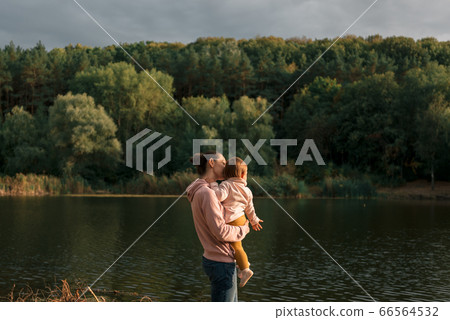 Mother and baby girl sitting near lake. Local travel. New normal vacation. Mother's day Mother and baby girl sitting near lake. Local travel. New normal vacation. Mother's day 66564532