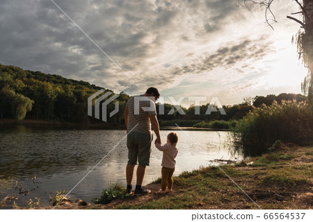 Father and baby girl sitting near lake. Local travel. New normal vacation. Father's day Father and baby girl sitting near lake. Local travel. New normal vacation. Father's day 66564537