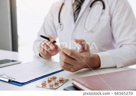 Confident doctor man holding a pill bottle and Confident doctor man holding a pill bottle and 66565270