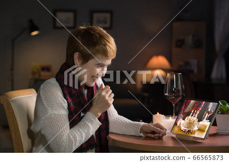 Asian middle aged woman feeling loved and happy while celebrating virtual birthday via video call Asian middle aged woman feeling loved and happy while celebrating virtual birthday via video call 66565873