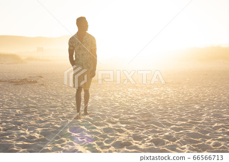 An African American man enjoying free time on beach on a sunny day An African American man enjoying free time on beach on a sunny day 66566713