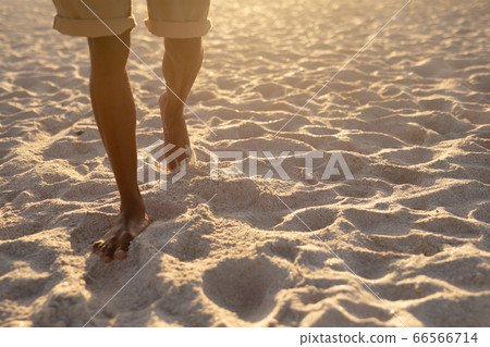 An African American man enjoying free time on beach on a sunny day 66566714