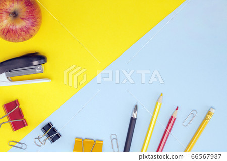 Bright stationery, red apple on blue yellow background. Back to school, workspace concept. Top view, flat lay, copy space, mock up, layout design Bright stationery, red apple on blue yellow background. Back to school, workspace concept. Top view, flat lay, copy space, mock up, layout design 66567987