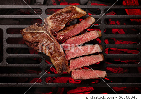 T-bone beef steak cooking on grill 66568343