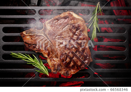 T-bone beef steak cooking on grill 66568346