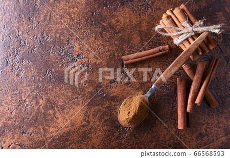 Cinnamon sticks and powder in spoon on a old Cinnamon sticks and powder in spoon on a old 66568593