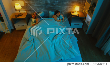 Young couple under the sheets can't sleep Young couple under the sheets can't sleep 66568951