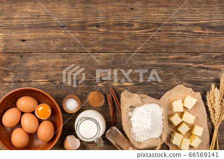 flour in a wooden bowl on dark wooden background 66569141