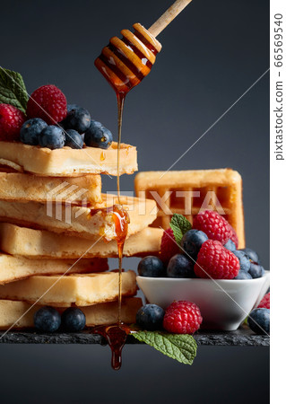 Belgian waffles with  blueberries, raspberries  66569540