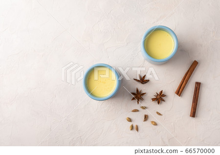 Two blue cups with traditional Indian masala chai tea with spices on a linen napkin on a light Two blue cups with traditional Indian masala chai tea with spices on a linen napkin on a light 66570000