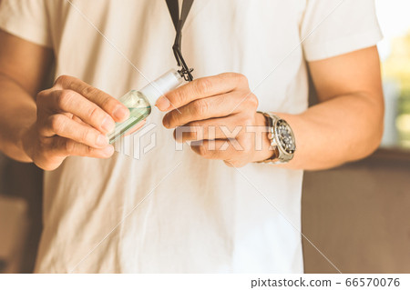 New normal man hand showing bottle sanitizer spray made for neck strap. New normal man hand showing bottle sanitizer spray made for neck strap. 66570076