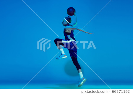 Young caucasian female basketball player isolated on blue studio background in neon light 66571192