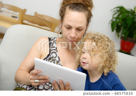 a child and her mom uses a  tablet 66575810