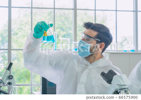Asian Scientist working on blue test tube to Asian Scientist working on blue test tube to 66575900