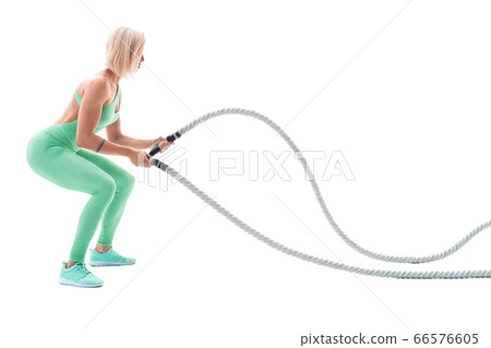 Woman doing exercises with battle rope. Woman doing exercises with battle rope. 66576605