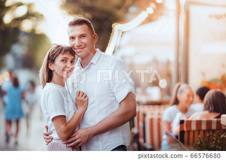 Happy attractive couple, charming woman hugging her handsome stylish boyfriend. Summer Europe vacation, date, romance Happy attractive couple, charming woman hugging her handsome stylish boyfriend. Summer Europe vacation, date, romance 66576680