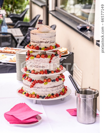 beautiful delicious Wedding cake in many tiers with fresh wild berries and fruits beautiful delicious Wedding cake in many tiers with fresh wild berries and fruits 66577149