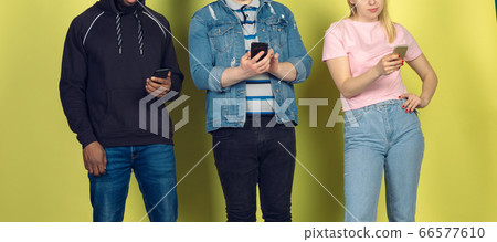 Group of friends using mobile smartphones. Teenagers addiction to new technology trends. Close up. Group of friends using mobile smartphones. Teenagers addiction to new technology trends. Close up. 66577610