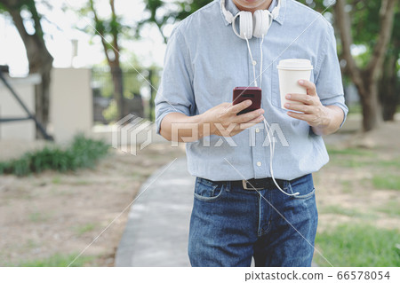 Businessman use smartphone and hold cup coffee in Businessman use smartphone and hold cup coffee in 66578054