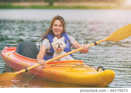 Woman and her dog on a kayak Woman and her dog on a kayak 66579073