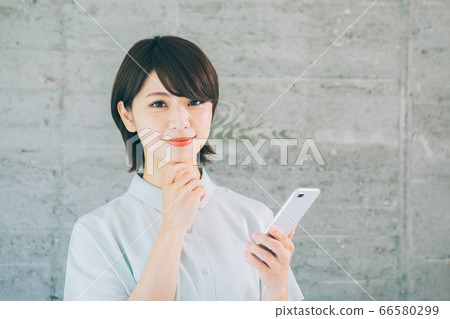 使用智能手機的年輕女性(*請避免在諸如婚姻活動和約會社之類的網站和應用上使用) 使用智能手機的年輕女性(*請避免在諸如婚姻活動和約會社之類的網站和應用上使用) 66580299