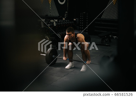 Muscular fit man with perfect beautiful body wearing sportswear lifting heavy barbell from floor Muscular fit man with perfect beautiful body wearing sportswear lifting heavy barbell from floor 66581526