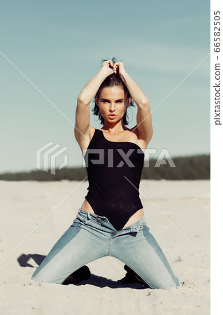 Stylish female on windy day on beach 66582505