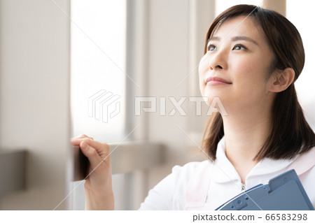 Medical worker woman looking at the future by the window Medical worker woman looking at the future by the window 66583298