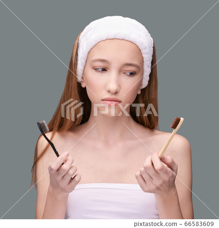 Girl hold toothbrush. Choice bamboo and plastic. Oral home routine Girl hold toothbrush. Choice bamboo and plastic. Oral home routine 66583609