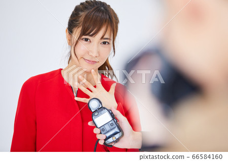 Young female model in red coat and photographer Young female model in red coat and photographer 66584160