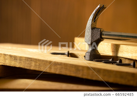 Hammer and screw on lumber in lighting and shadow of the sunshine in morning. The concept of woodcraft or carpentry. 66592485