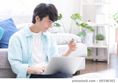 年輕人看著電腦享受在線購物 66596365