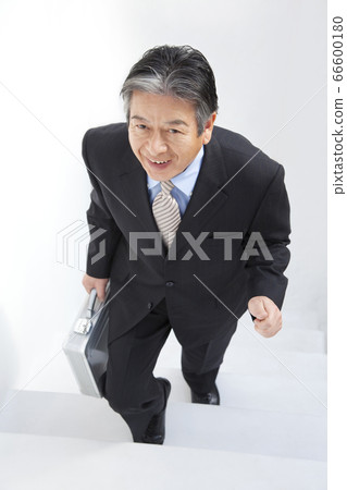 A businessman going up the stairs A businessman going up the stairs 66600180