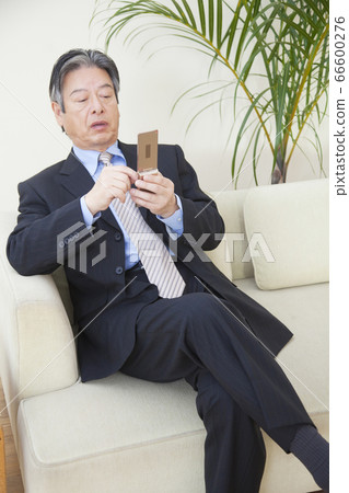 Businessman watching mobile phone Businessman watching mobile phone 66600276