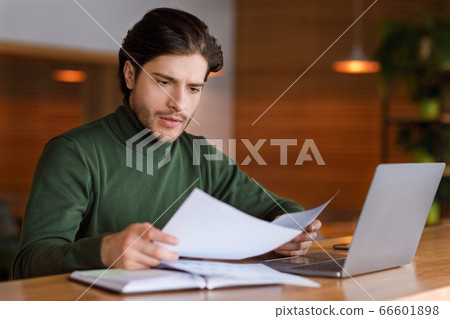 Businessman working with documents and laptop at cafe Businessman working with documents and laptop at cafe 66601898