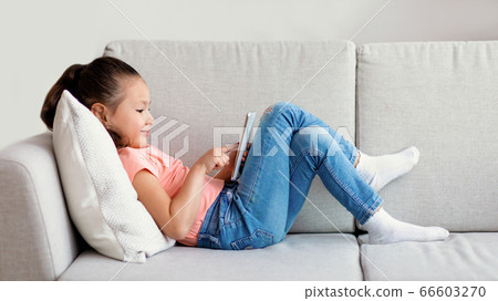 Girl Using Smartphone Playing Games Lying On Sofa Indoor, Panorama 66603270