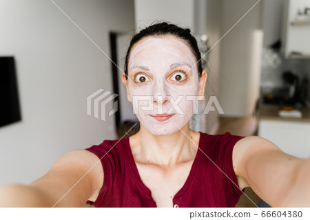 Caucasian woman with face mask live streaming as a beauty blogger 66604380