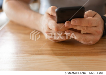 Man hands with phone on wooden background. 5g, virtual life, online work and education. 66604381