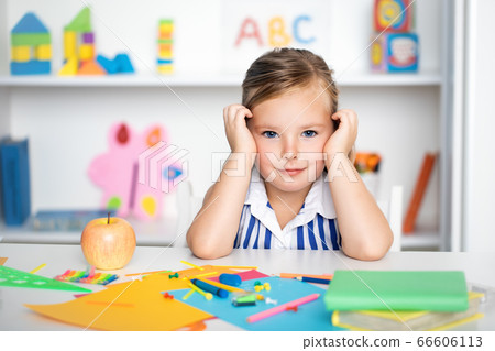 Little girl sitting at desk in room 66606113