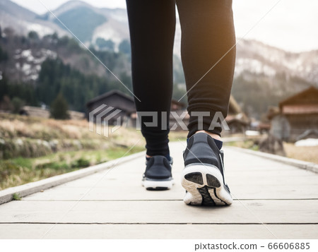 Woman wearing sport shoe walking on pathway outdoor Mountain landscape Woman wearing sport shoe walking on pathway outdoor Mountain landscape 66606885
