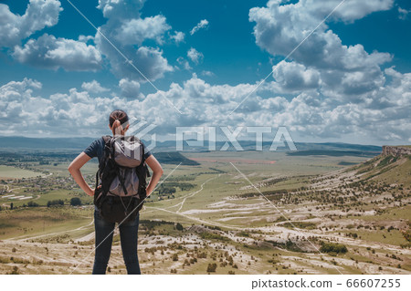 Hiker with backpack relaxing on top of a mountain Hiker with backpack relaxing on top of a mountain 66607255
